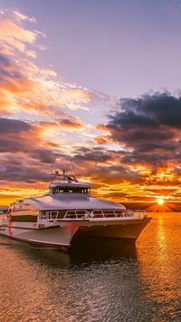 Katamaran na morzu z zachodzącym słońcem