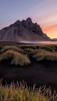 Kępki traw na czarnym piasku i góra Vestrahorn