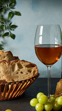 Kieliszek wina obok chleba w koszyku
