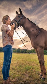 Kobieta całująca konia na łące