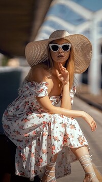 Kobieta w letniej sukience okularach i kapeluszu