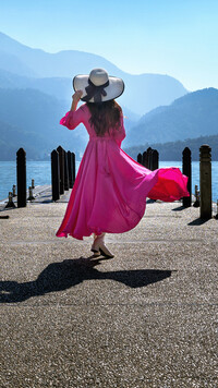 Kobieta w różowej sukience i kapeluszu