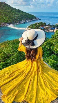 Kobieta w żółtej sukience na skale