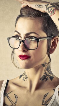 Kobieta z tatuażami i w okularach