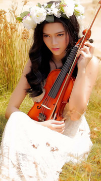 Kobieta ze skrzypcami w trawie