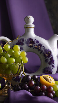 Kolorowe kiście winogron obok imbryka