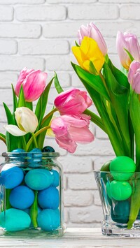 Kolorowe tulipany i pisanki w naczyniach