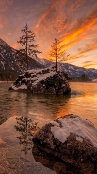 Kolorowy zachód słońca nad jeziorem Hintersee zimą