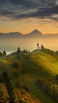 Kościół św Primusa i Felicjana na tle Alp Julijskich