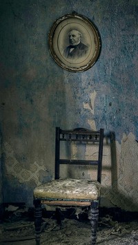 Krzesło i portret na ścianie w starym pokoju