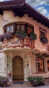Kwiaty i kolorowe malowidła na fasadzie domu