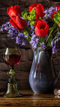 Kwiaty w dzbanku i kieliszek z winem