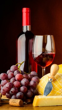 Lampka wina koło butelki i winogron
