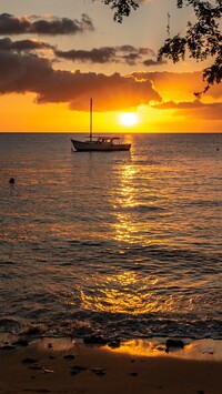 Łódka na morzu o zachodzie słońca