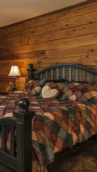 Łóżko w sypialni z drewnianymi ścianami