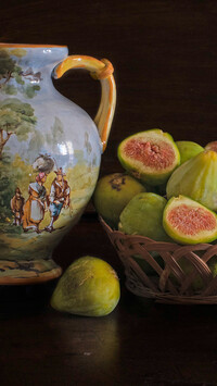 Malowany dzban obok fig w koszyczku