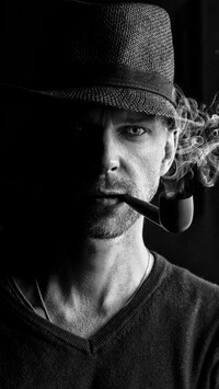 Mężczyzna w kapeluszu z fajką