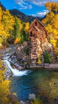 Młyn Crystal Mill na skale w jesiennej scenerii