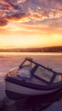 Motorówka na brzegu jeziora zimą