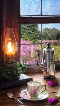 Naftowa lampa i dzbanek przy oknie