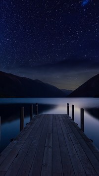 Noc z gwiazdami nad jeziorem i pomostem