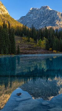 Odbicie rozświetlonych gór i drzew w Emerald Lake