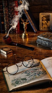 Okulary na książce obok dymiącej fajki
