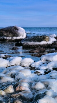 Ośnieżone kamienie na brzegu morza