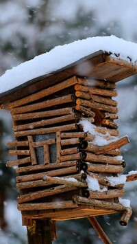 Ośnieżony drewniany domek dla ptaków