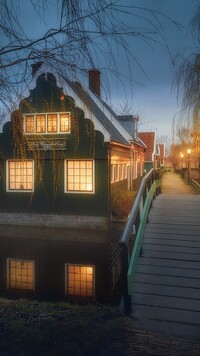 Oświetlony dom i most nad kanałem