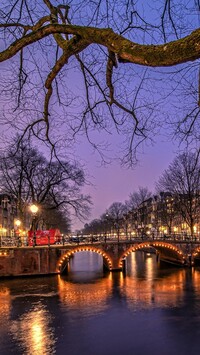 Oświetlony most nad kanałem w Amsterdamie