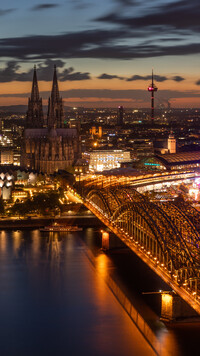 Oświetlony nocą most Hohenzollernów w Kolonii
