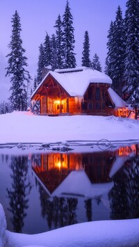 Oświetlony zaśnieżony dom nad jeziorem Emerald Lake