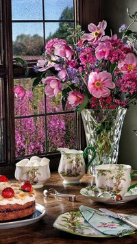 Serwis kawowy i kwiaty w wazonie przy oknie