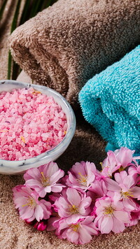 Sól kąpielowa i kwiaty obok ręczników