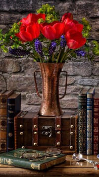 Tulipany w wazonie obok książek