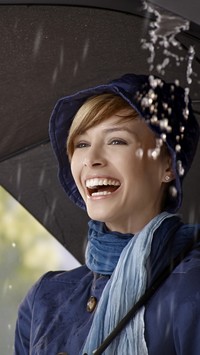 Uśmiechnięta kobieta pod parasolem