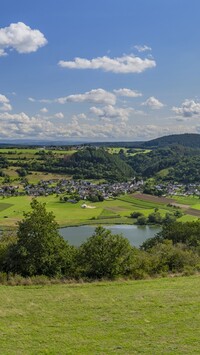 Widok ze wzgórza na jezioro i domy