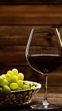 Winogrona obok lampki wina