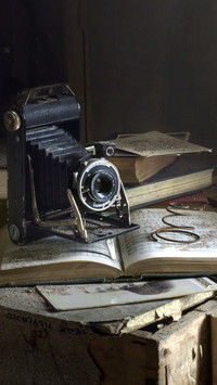 Zabytkowy aparat fotograficzny na książce
