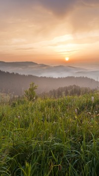 Zachód słońca nad górami i łąką