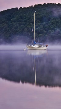 Żaglówka na jeziorze we mgle