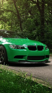 Zielone BMW na leśnej drodze