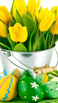 Żółte tulipany w wiaderku i pisanki wielkanocne