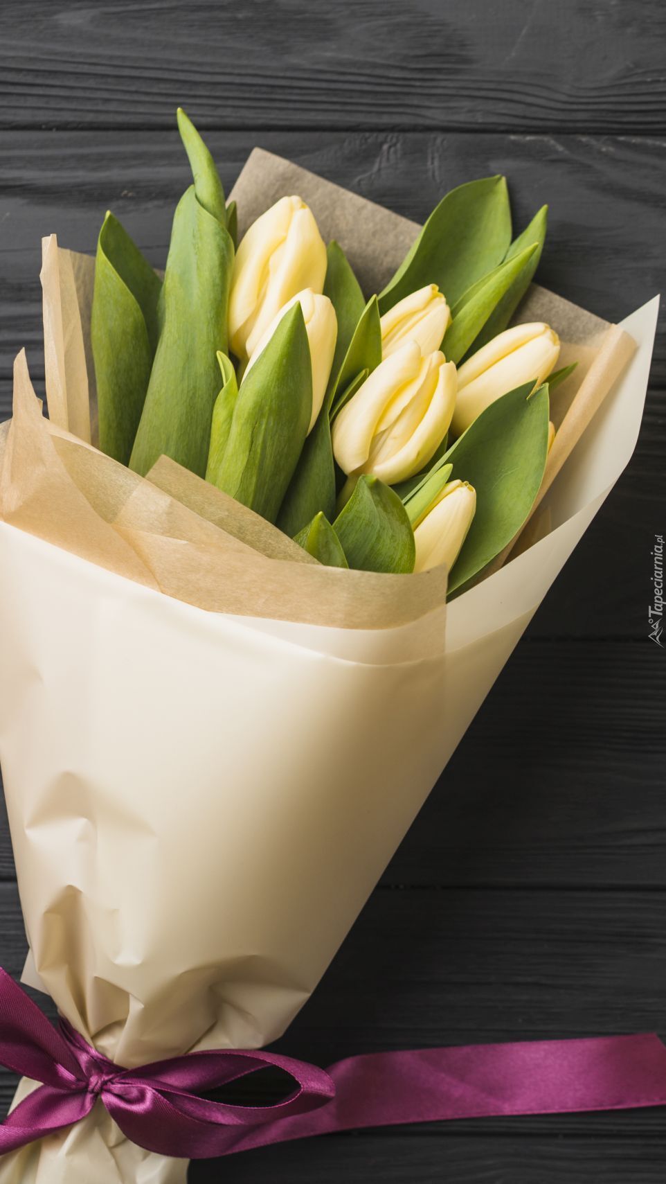 Białe tulipany owinięte papierem ze wstążką