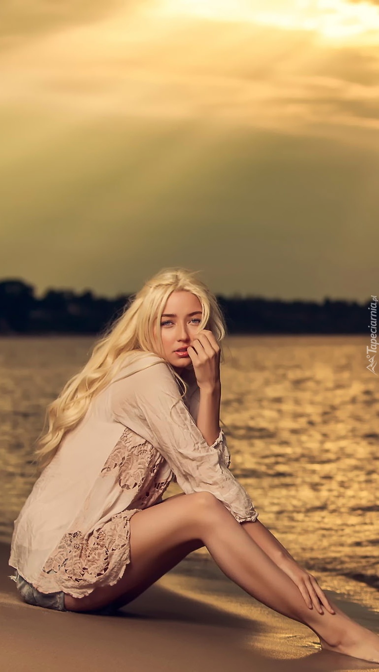 Blondynka na piasku nad jeziorem