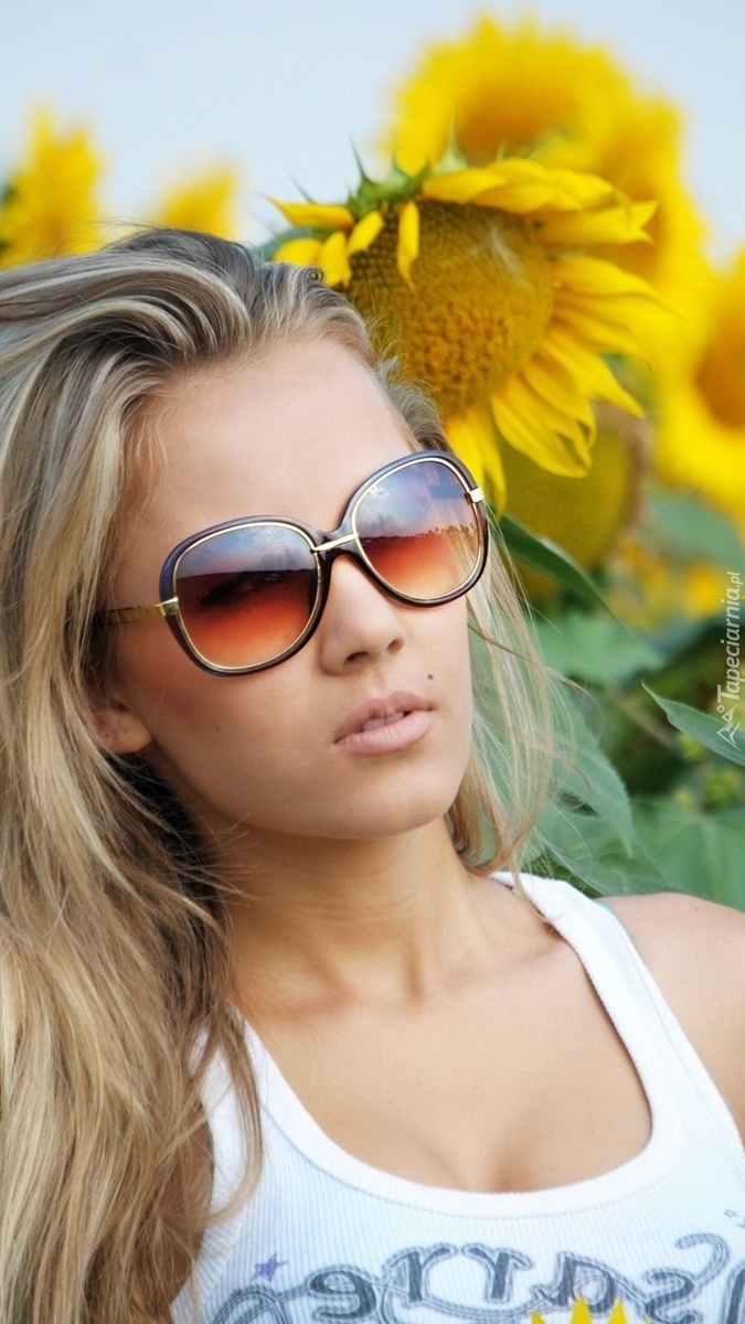 Blondynka w okularach wśród słoneczników