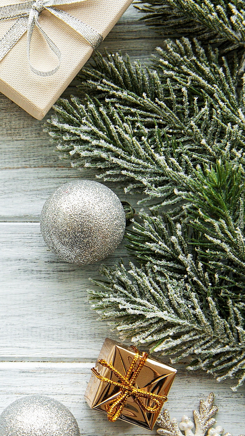 Bombki i prezenty obok gałązek