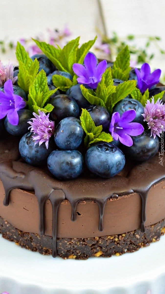 Borówki i kwiaty na czekoladowym torciku