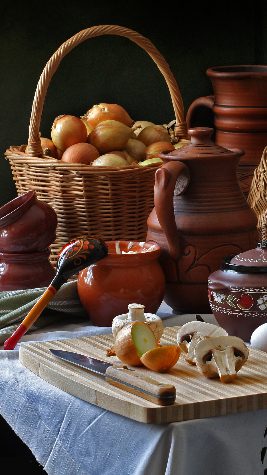 Cebula w koszu obok ceramicznych naczyń